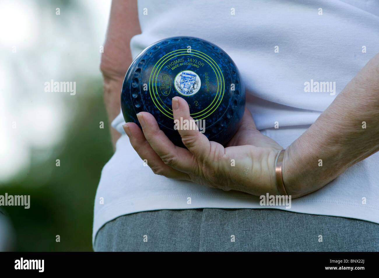An old female arm/hand holding a bowls bowl ready to roll it at the