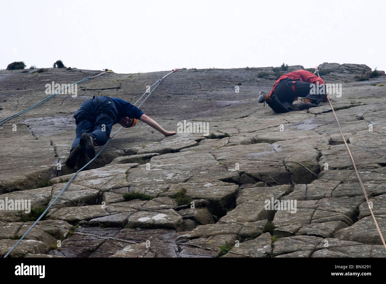 Two Men rock climbing at Barmouth Slabs nr Barmouth Gwynedd Mid Wales