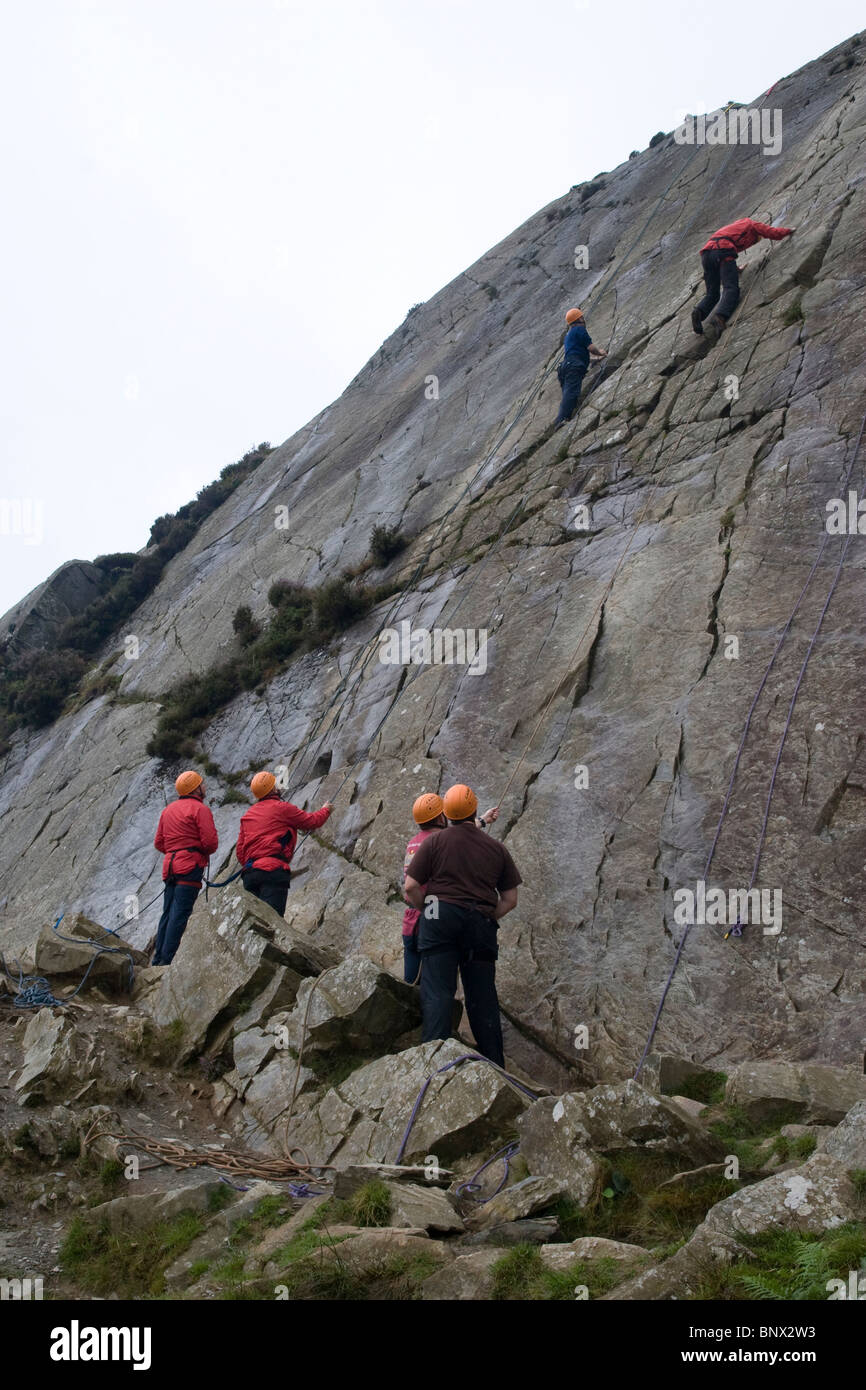 Group of outdoor activity students climbing at Barmouth Slabs nr