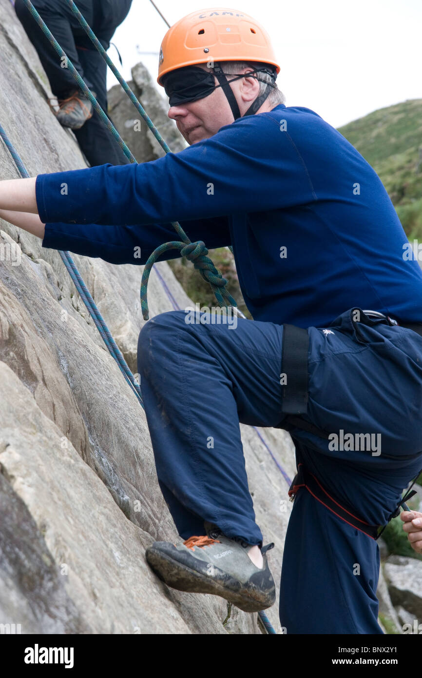 Man rock climbing blindfolded at Barmouth Slabs nr Barmouth Gwynedd Mid