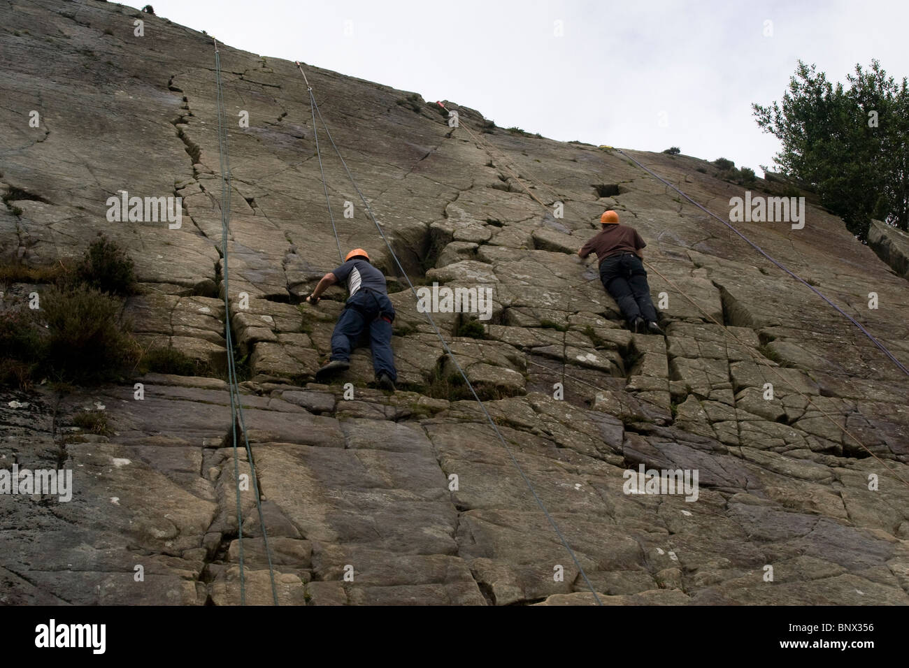 Two Men rock climbing at Barmouth Slabs nr Barmouth Gwynedd Mid Wales