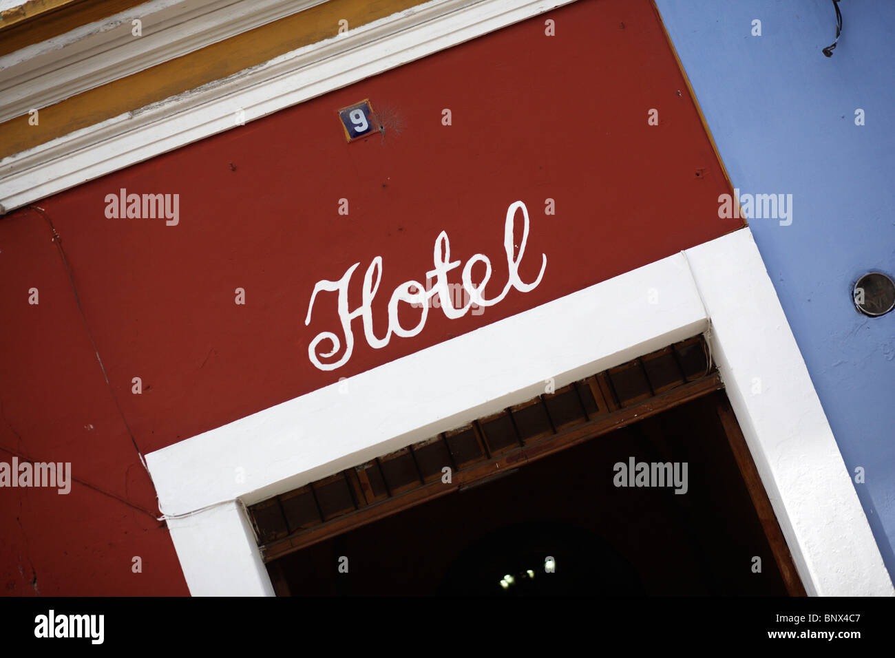 Red Rope Hotel. Sign A sign for a hotel painted onto a colourful red wall in Antigua near ...