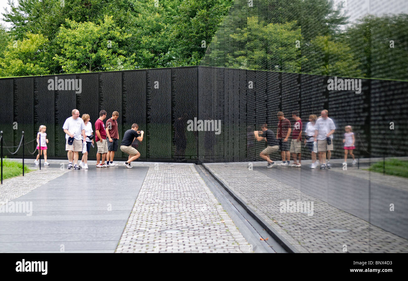 WASHINGTON DC, USA - Visitors to the Vietnam War Memorial in Washington DC, with a refleective wall with names of those US soldiers killed in the war. Stock Photo