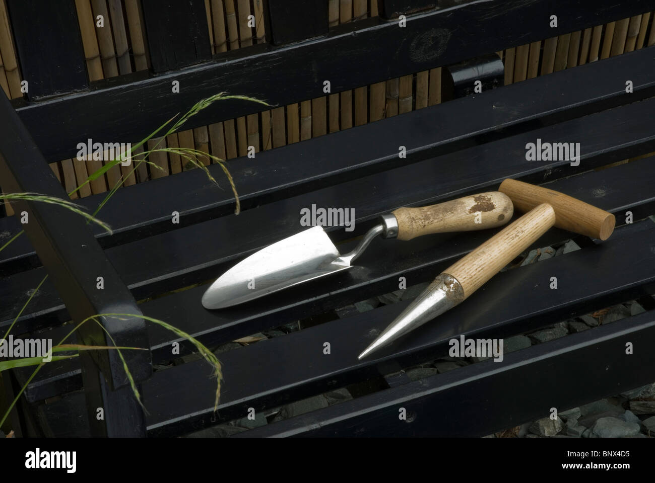 Hand trowel and dibber on a garden seat Stock Photo