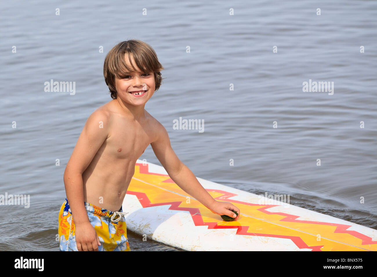Young boy playing with surfboard on Lake Winnipeg, Gimli, Manitoba, Canada. Stock Photo