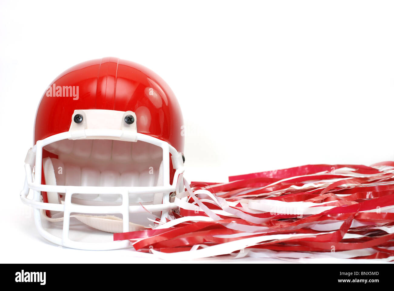 Red football helmet and pom poms isolated on white background. Stock Photo