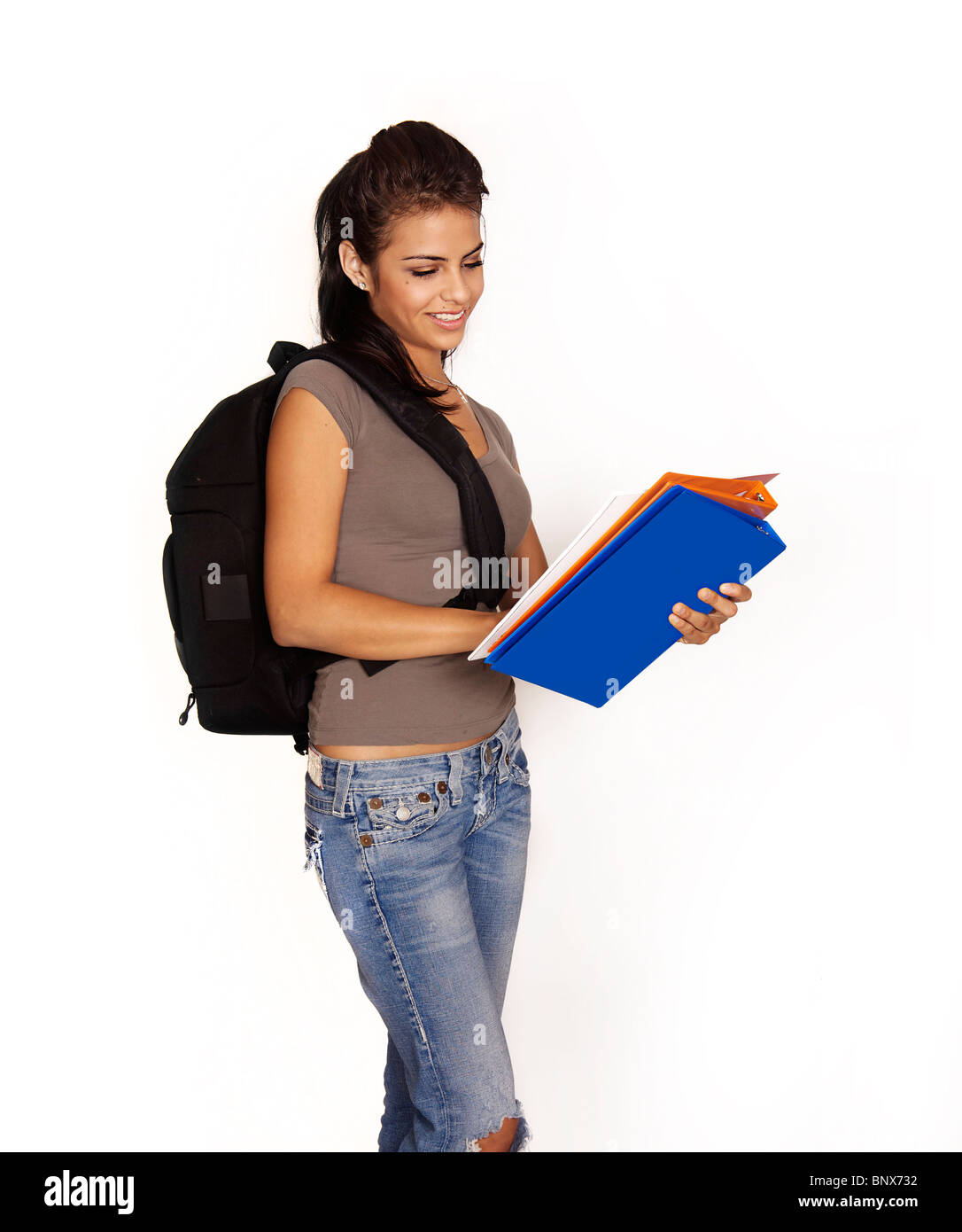 Attractive young female student with backpack and books smiling going ...