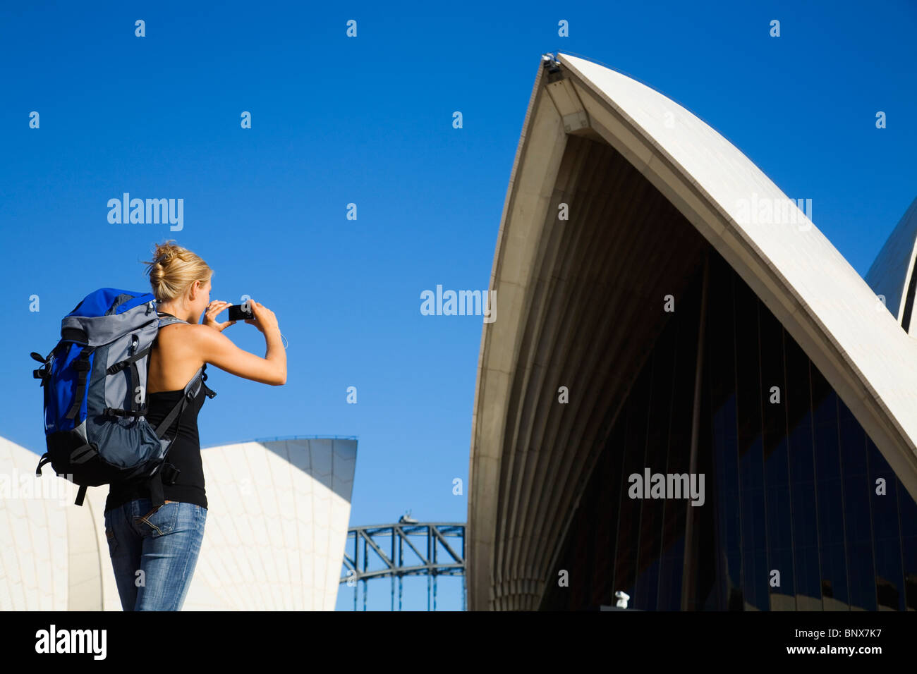 A backpacker photographs the Opera House in Sydney, New South Wales, AUSTRALIA. Stock Photo