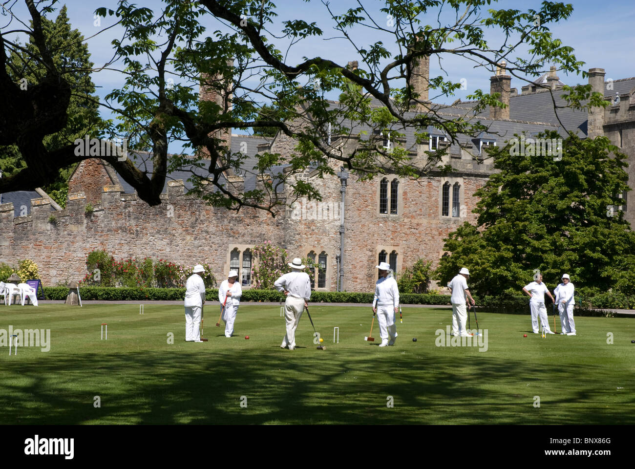 Croquet players on the lawn Bishops Palace grounds Wells Somerset, UK Stock Photo