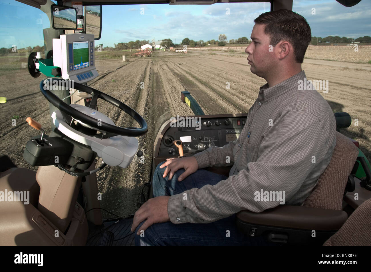 A tractor driver with GPS navigation for accurate field grading Stock