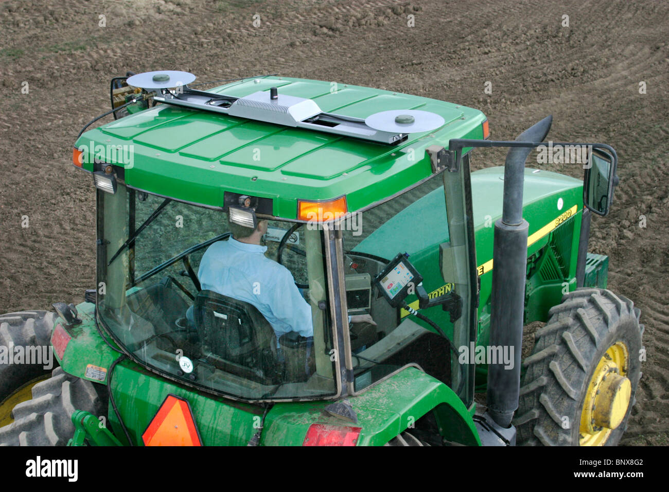 A tractor driver with GPS navigation for accurate field grading Stock Photo  - Alamy