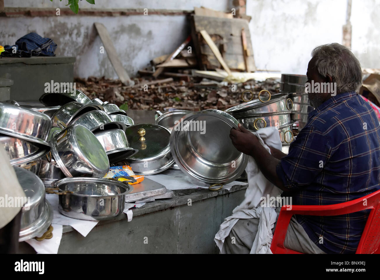 Man busy cleaning utensils in an Indian kitchen Stock Photo Alamy
