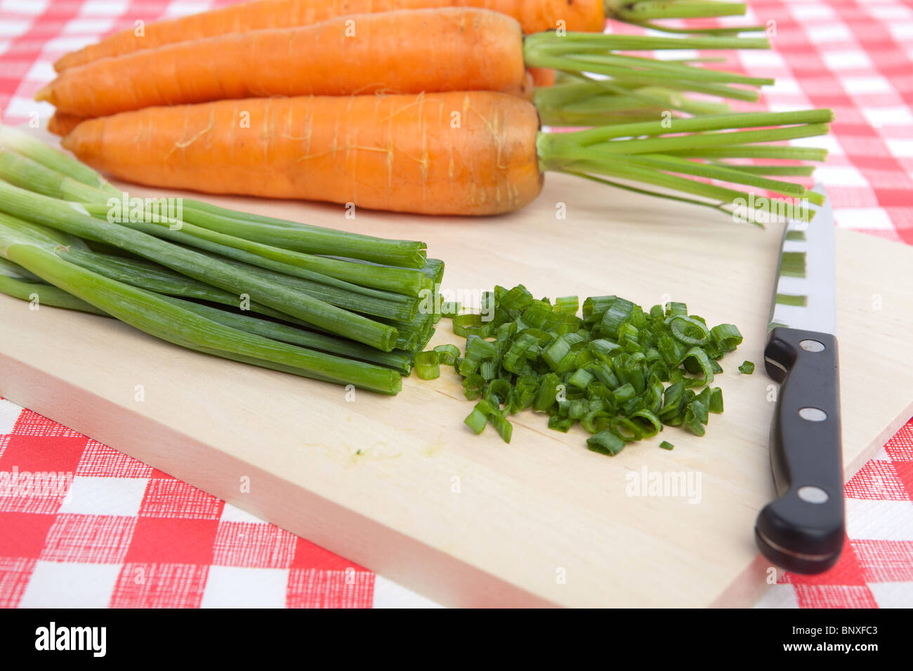 Chopped Spring Onion and Carrots on a Chopping Board Stock Photo