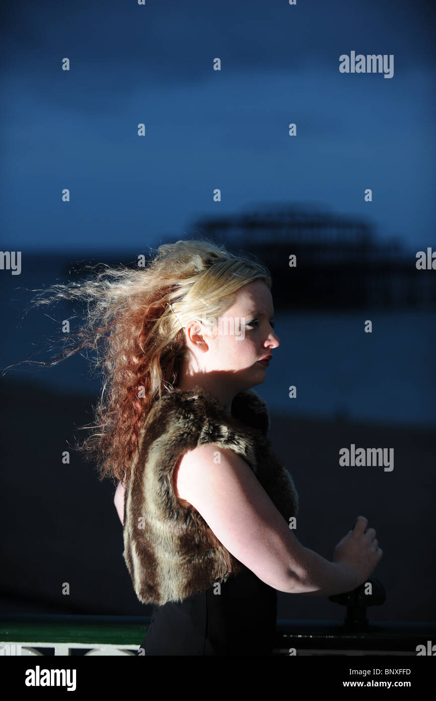 Blonde hair model with avant garde style fashion black dress on Brighton seafront near the West Pier UK Stock Photo