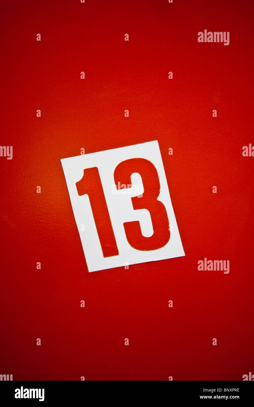 Number thirteen against red background Stock Photo