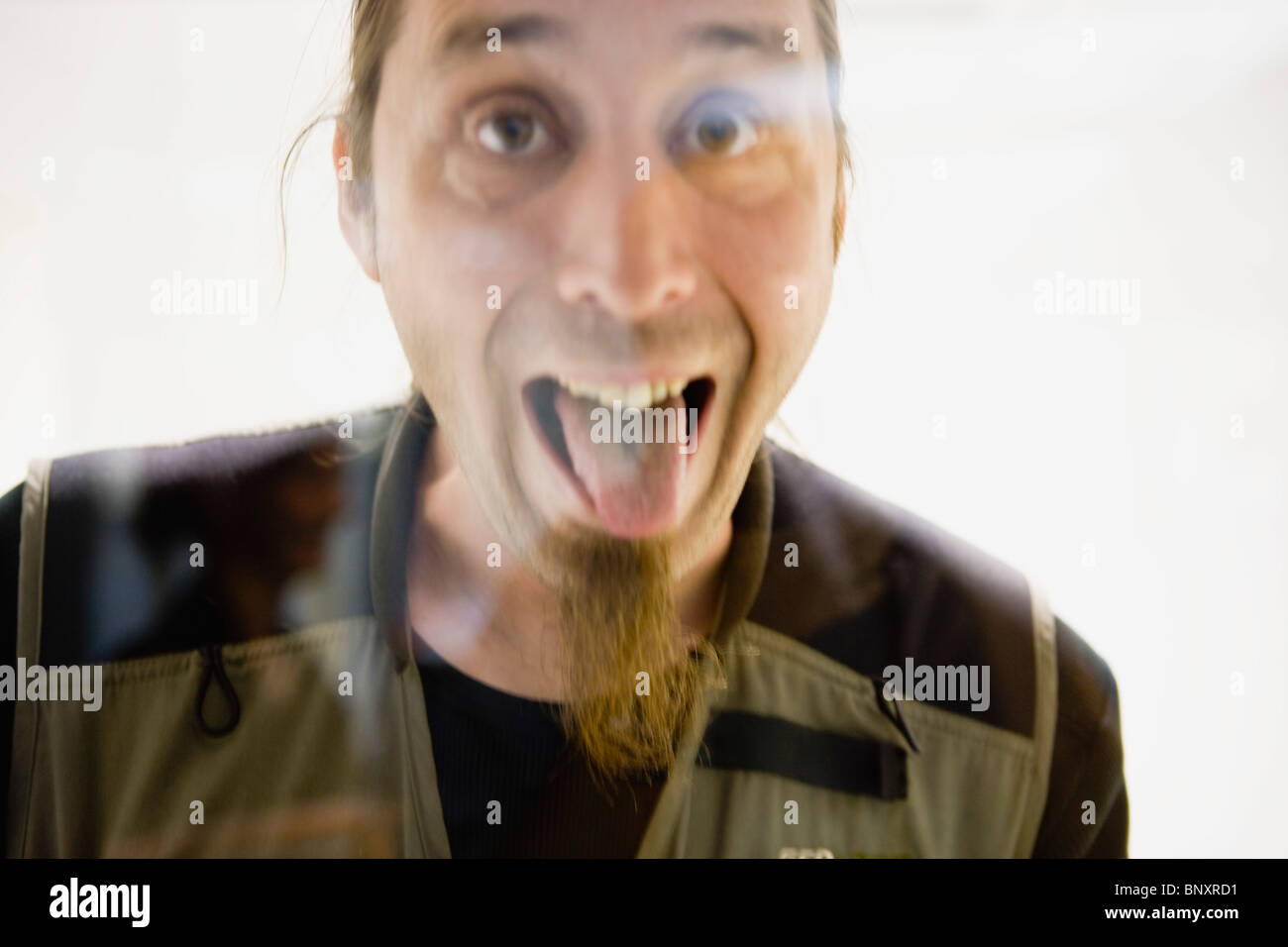 Man with long soul patch sticking out tongue at camera Stock Photo