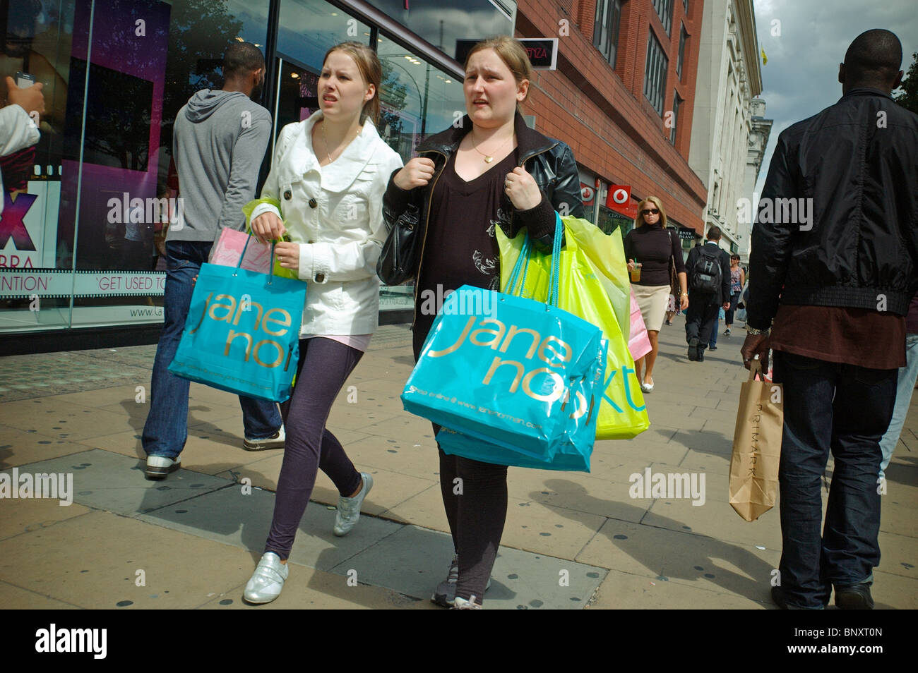 Two young woman shoppers on Oxford Street with shopping bags Stock Photo