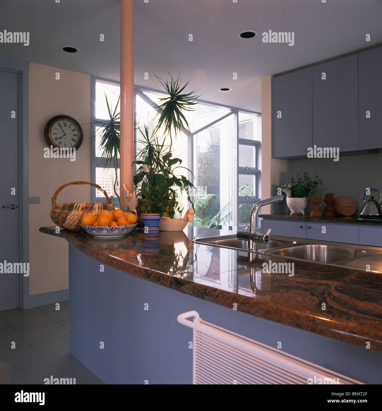 Basket Of Oranges On Island Unit With Brown Granite Worktop In