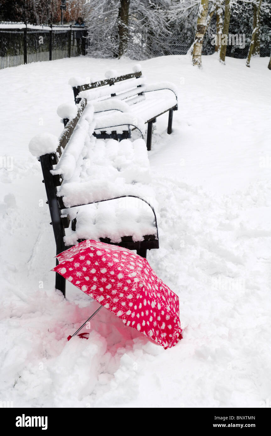 A red umbrella in the snow by a bench. Wrington, Somerset England Stock ...
