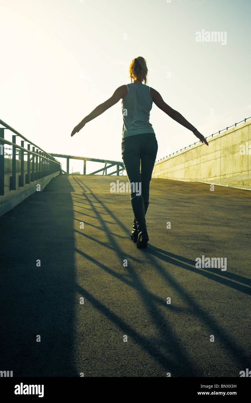 Balancing On Railing Teen girl walking on shadow of railing on sidewalk as if balancing on ...