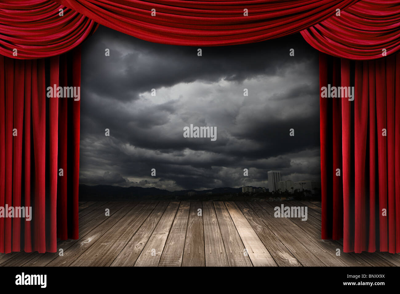 Bright Stage With Red Velvet Theater Curtains and Dramatic Sky Background Stock Photo