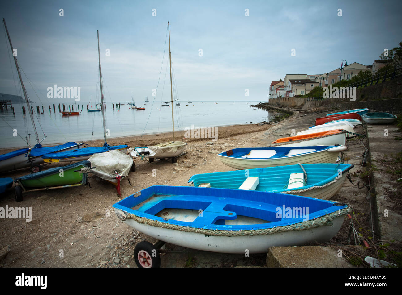Small boats at Swanage sailing club looking towards Peverell Point, Dorset, Uk Stock Photo