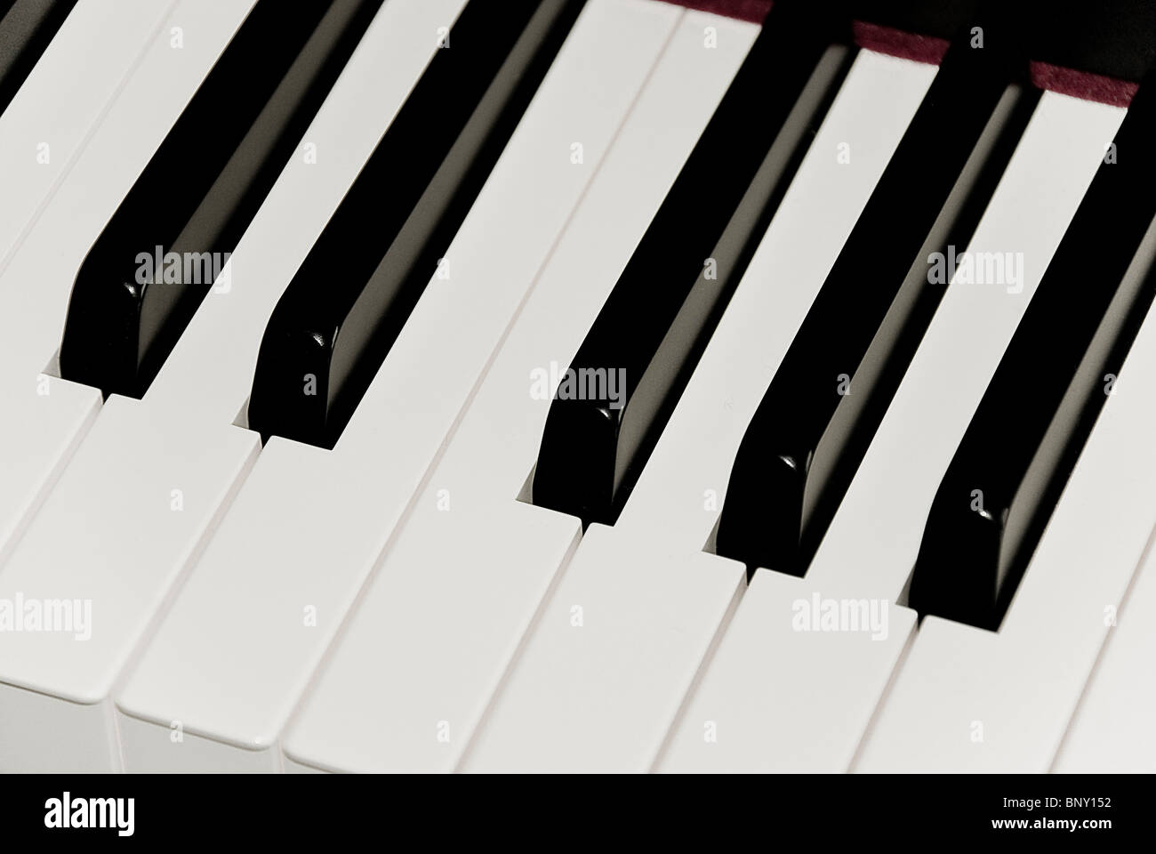 A closeup of black and white keys of piano keyboard featuring one