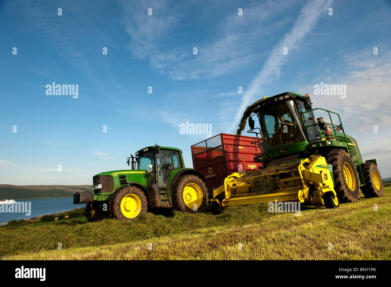 Silage making on the coast near Stranraer with John Deere tractor and chopper Stock Photo