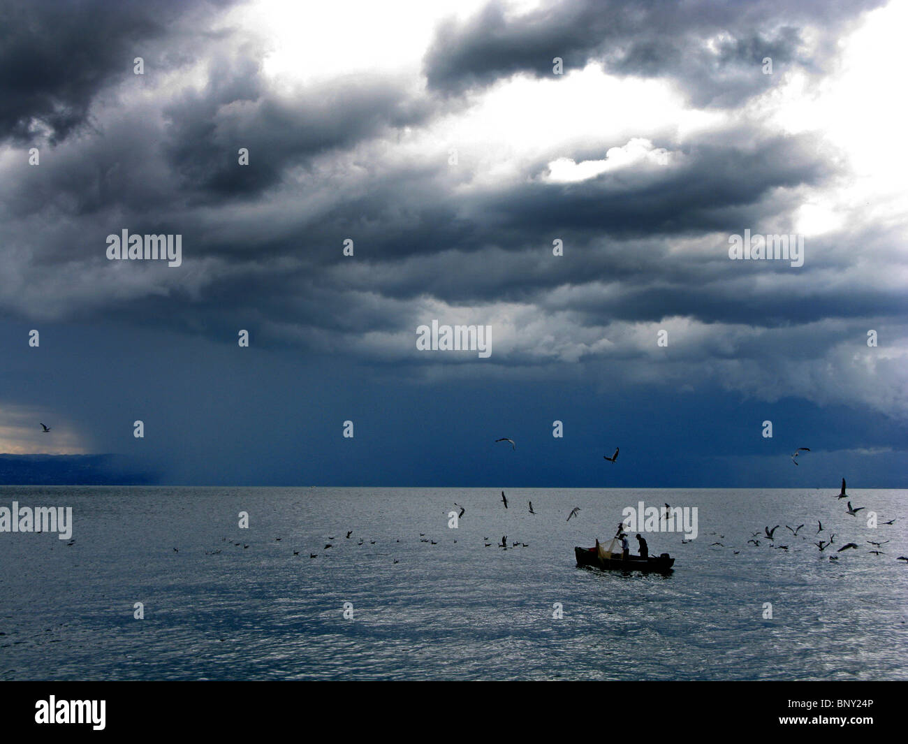 Stormy weather and small fishing boat on  Lac Leman, Lake Geneva at Evian in France Stock Photo
