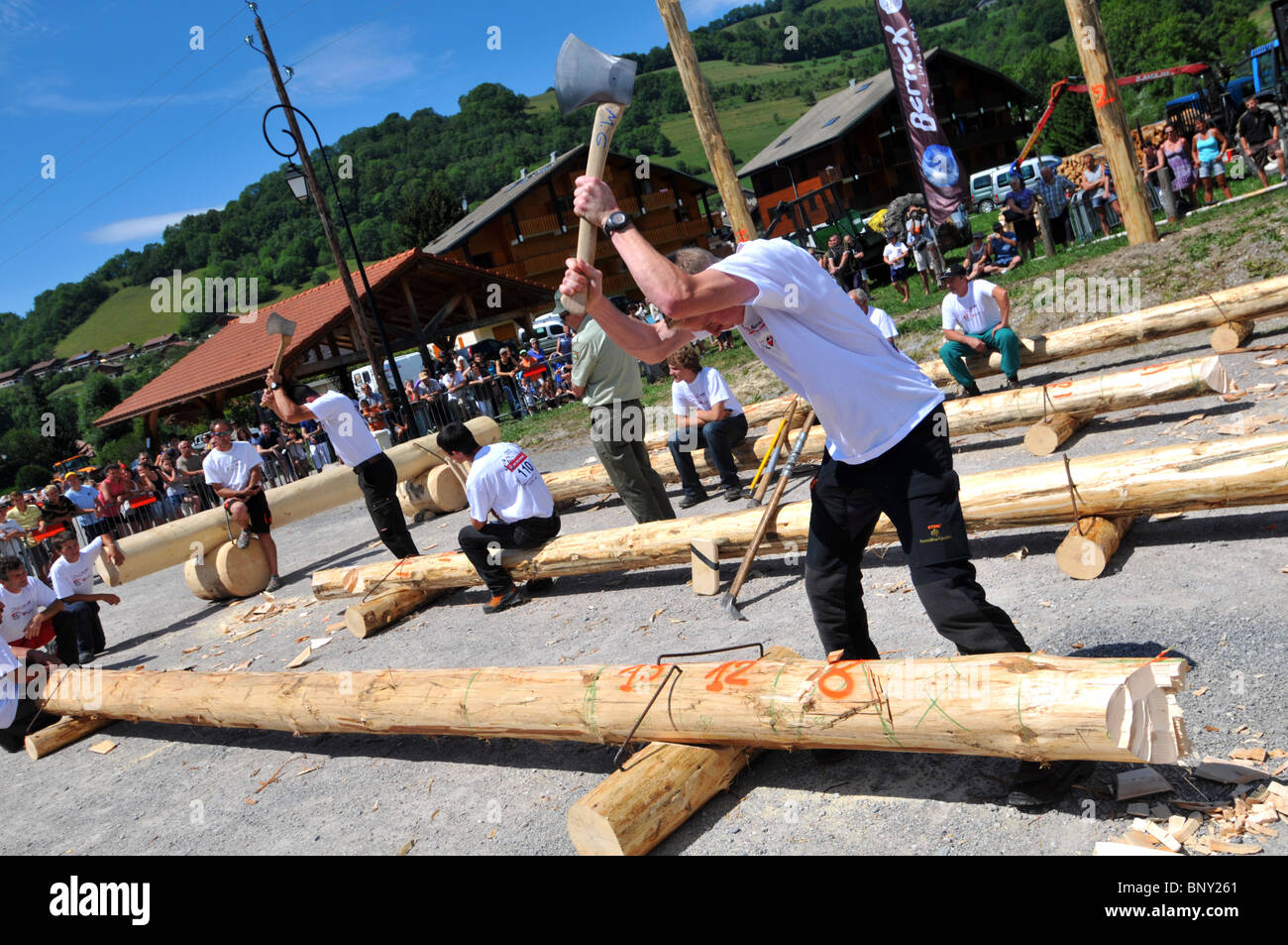 Wood chopping competition, men compete chopping logs with axes during a