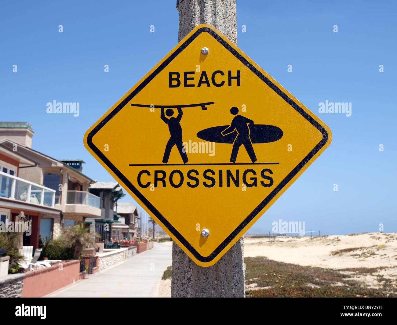 Beach crossing warning sign along a busy Southern California bike route. Stock Photo