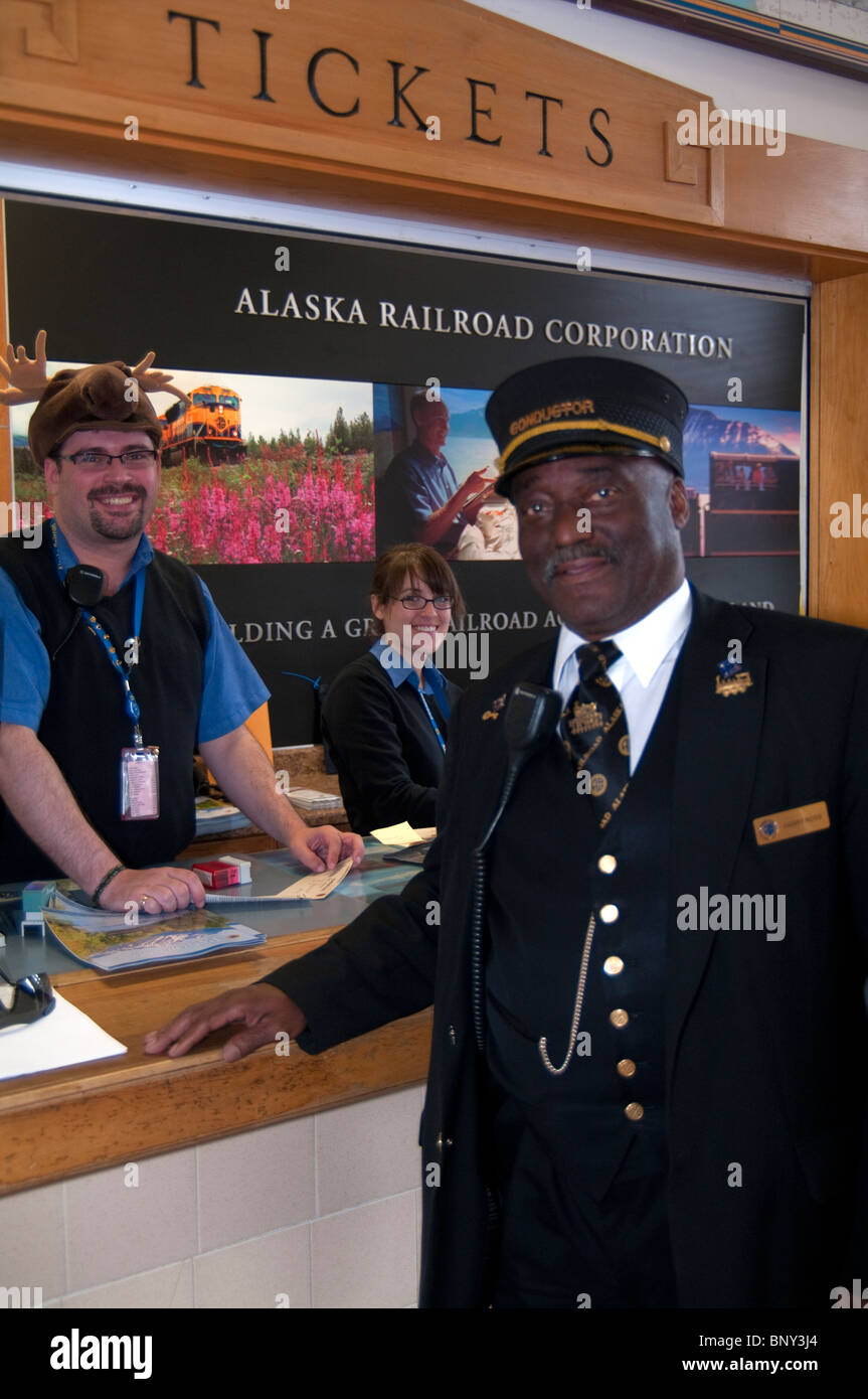 Conductor greets guest at the Alaska Railroad ticketing area Stock Photo
