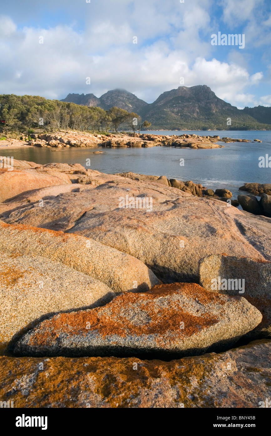 The rocky shoreline of Coles Bay with The Hazards mountain range beyond. National Park