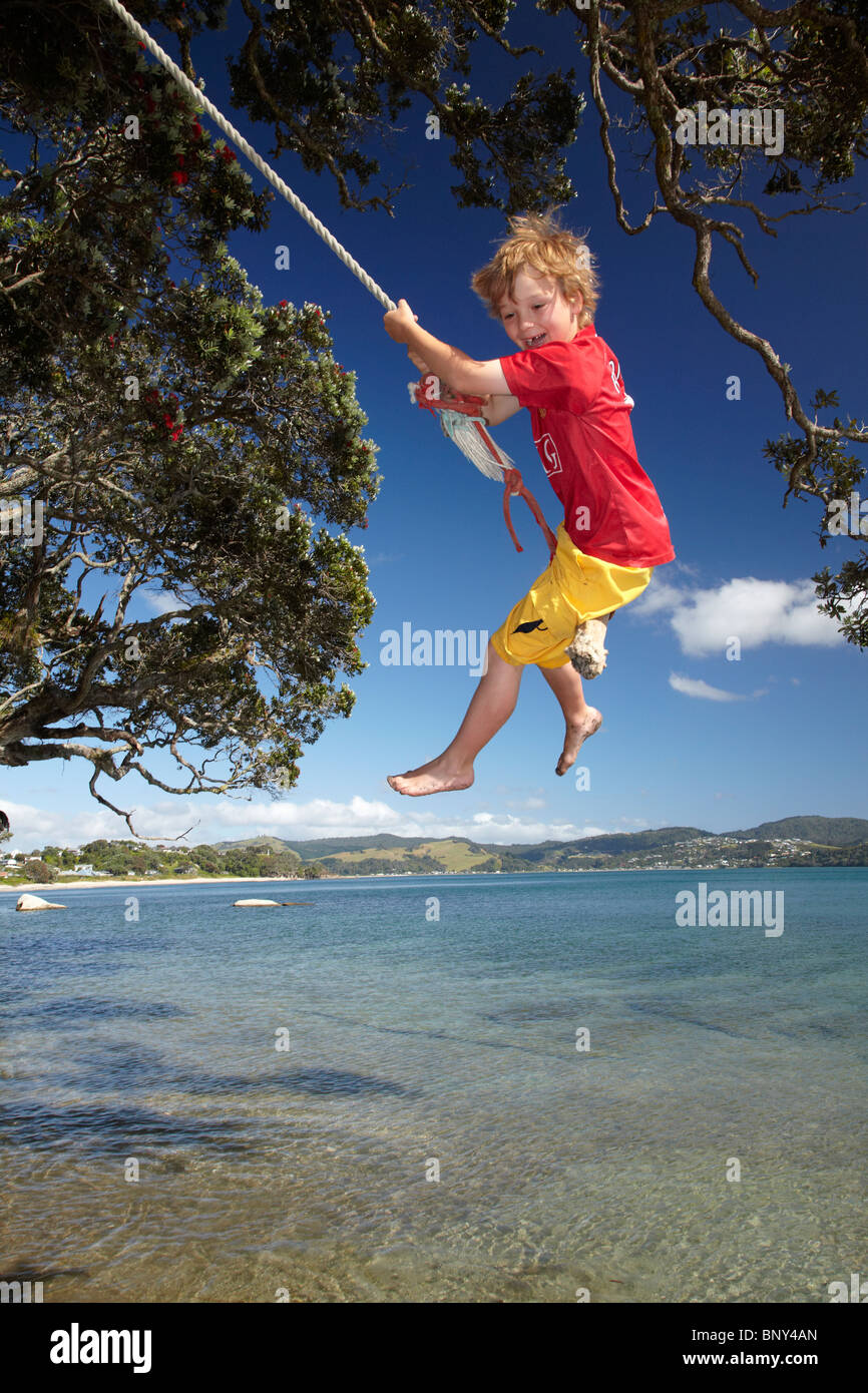 New Zealand Photos  Young boy smiling and sharing a rope swing