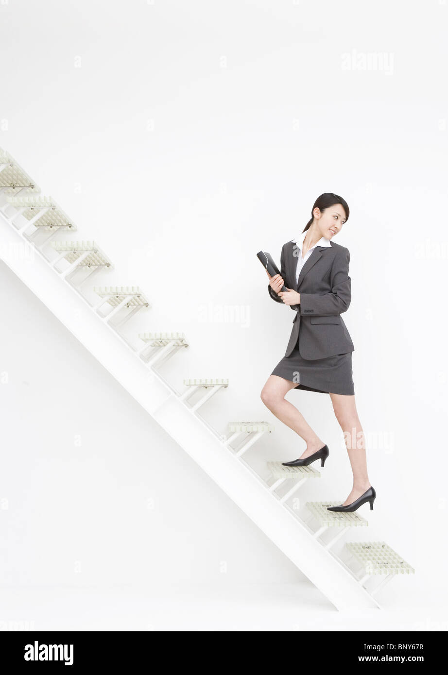 Business woman walking up the stairs Stock Photo - Alamy