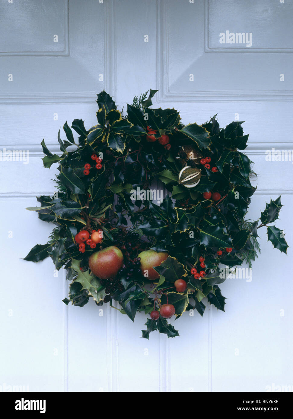 Closeup of homemade holly and ivy Christmas wreath on white front