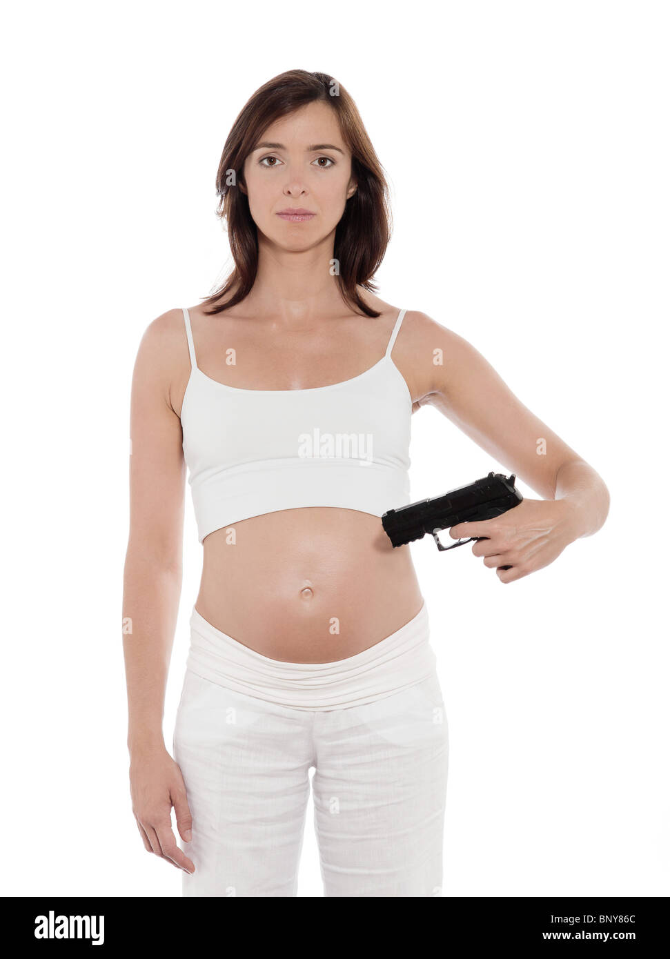 pregnant caucasian woman portrait pointing gun on belly abortion concept isolated studio on white background Stock Photo