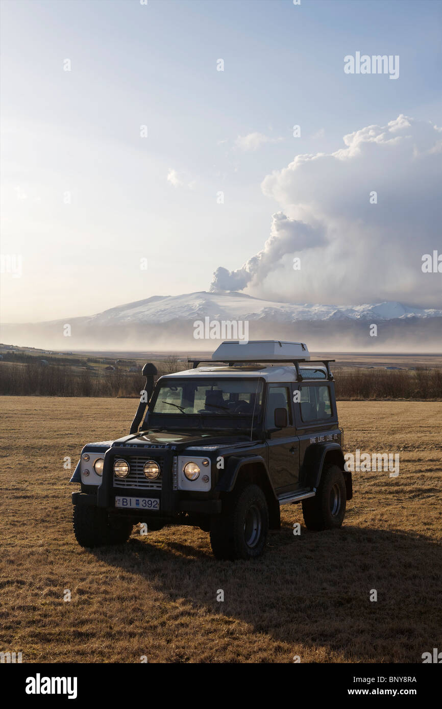 Land Rover Defender 90 300TDI in front of Eyjafjallajokull Volcan erupting in the background Stock Photo