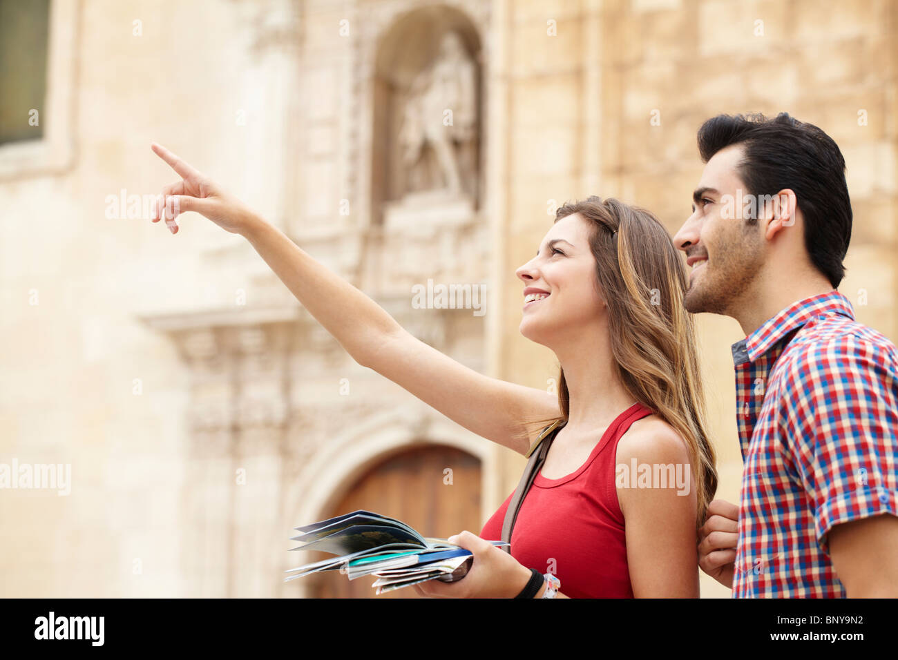 Smiling young woman pointing out sights Stock Photo
