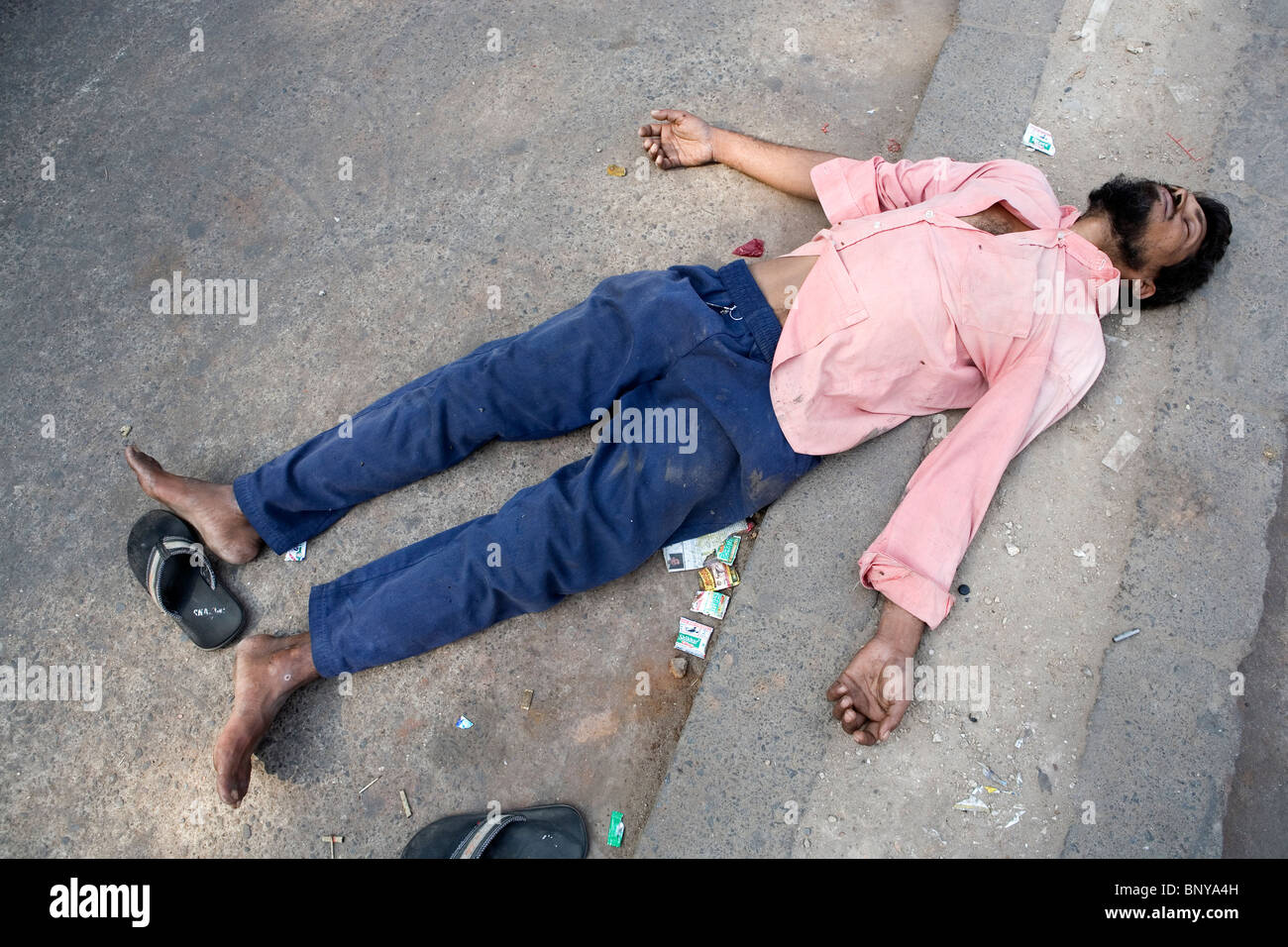 A poor Indian man is sleeping on the street in Delhi, India. Stock Photo