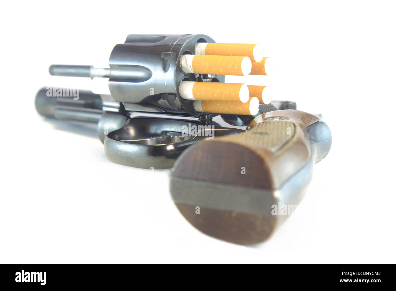 Revolver loaded with cigarettes to symbolize the dangers of smoking Stock Photo