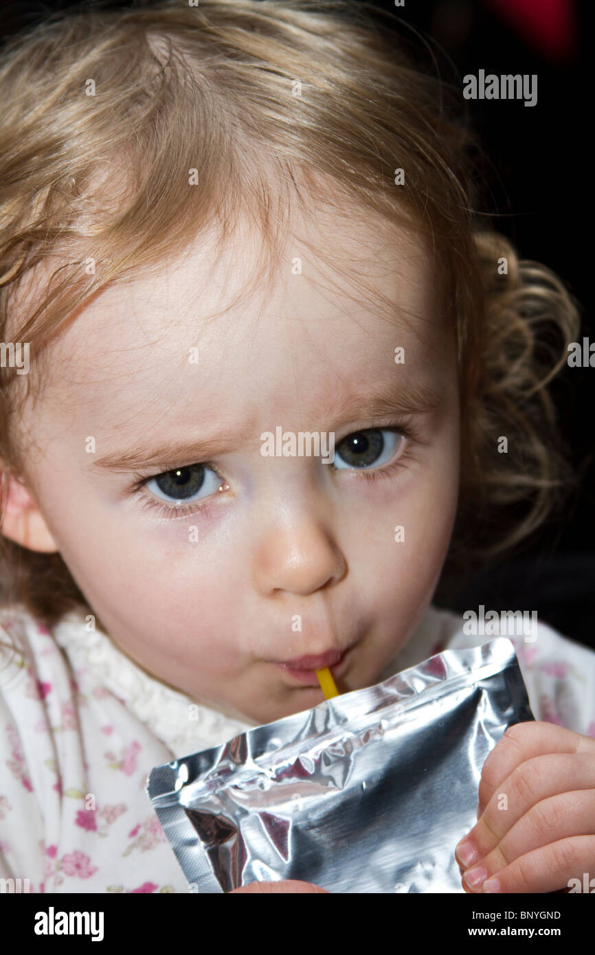 Preschool toddler drinking juice through a straw Stock Photo Alamy
