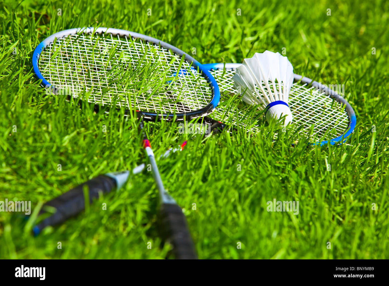 Badminton rackets on green grass. Stock Photo
