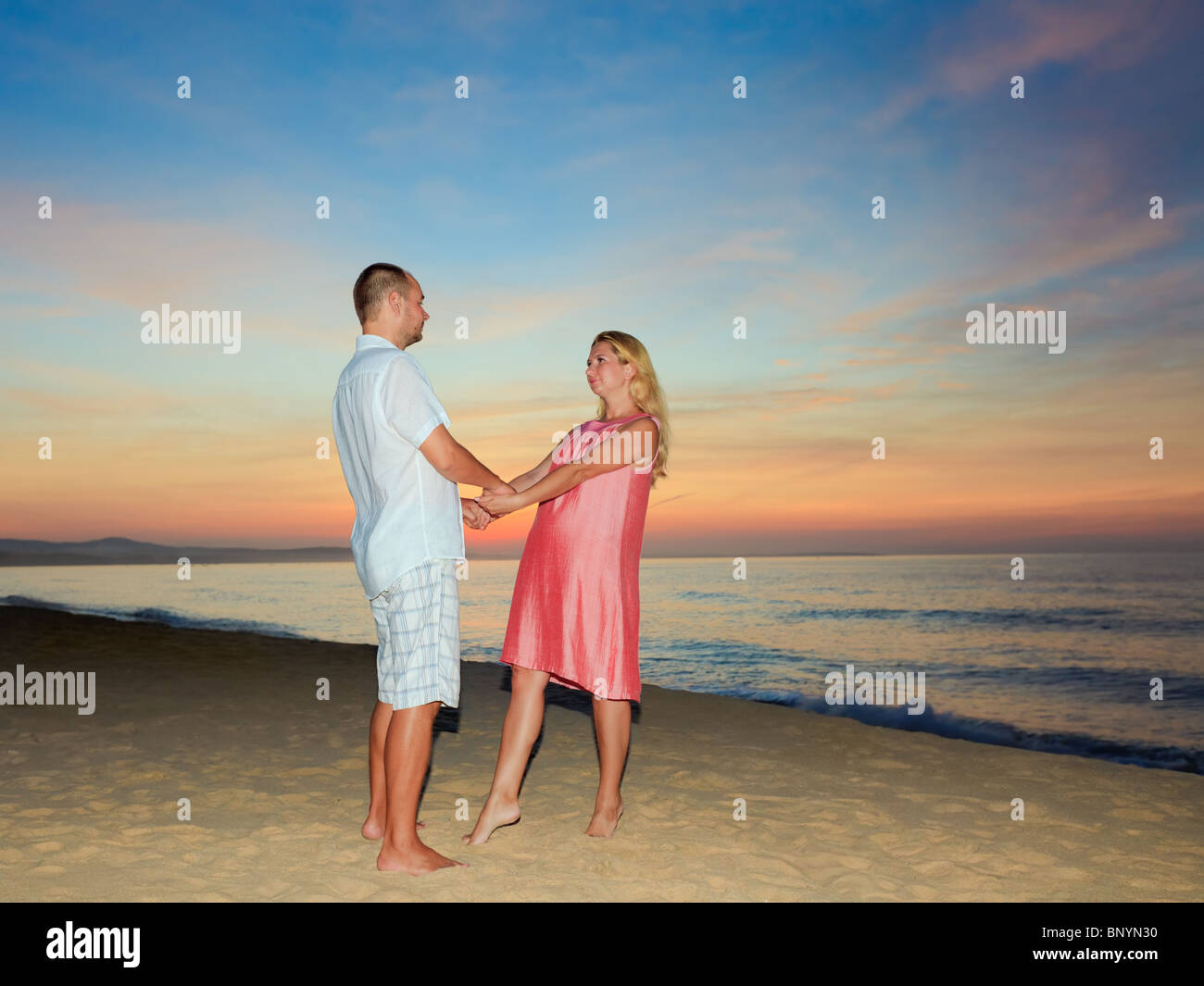 Romantic couple on the beach at sunrise time Stock Photo - Alamy