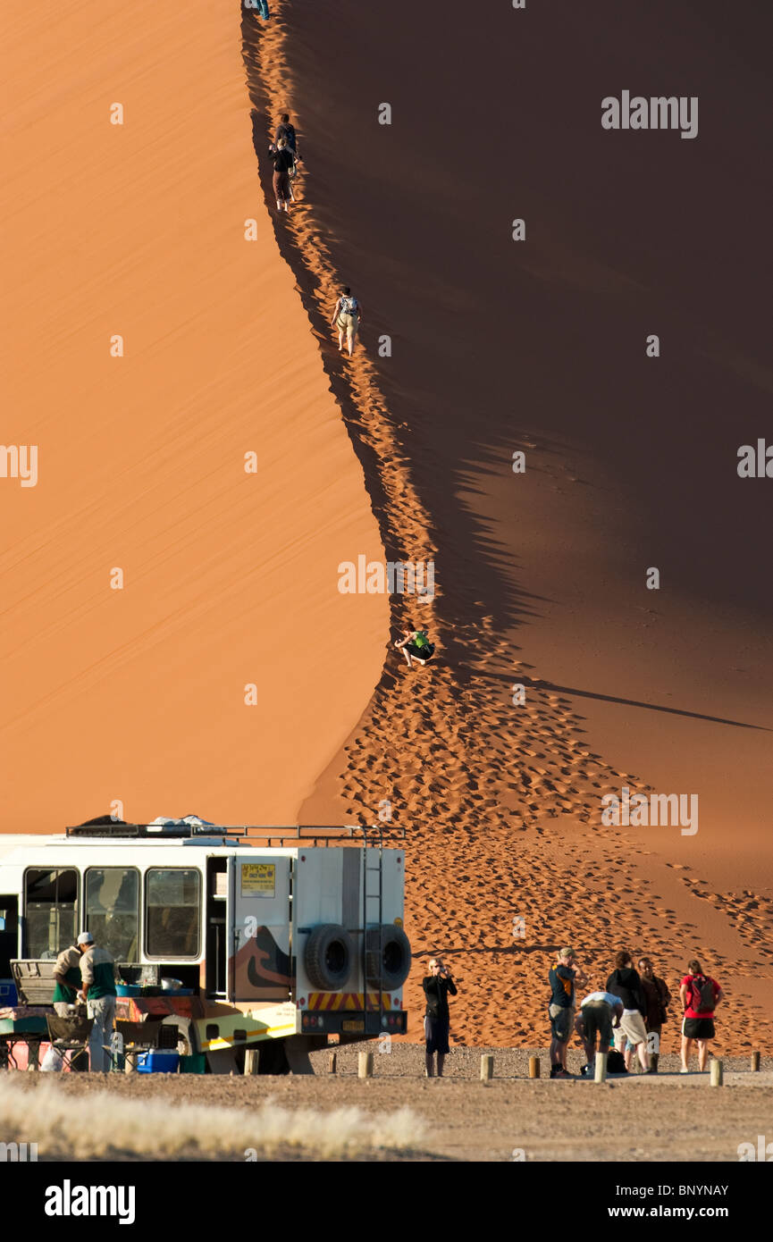 Tourists ascending dune 45 at Sossusvlei in Naukluft Park Central Namib desert Namibia Stock Photo