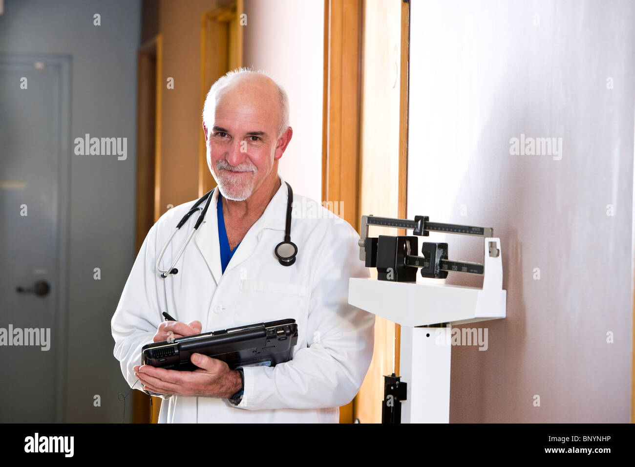 Doctor standing in hallway next to scale Stock Photo Alamy