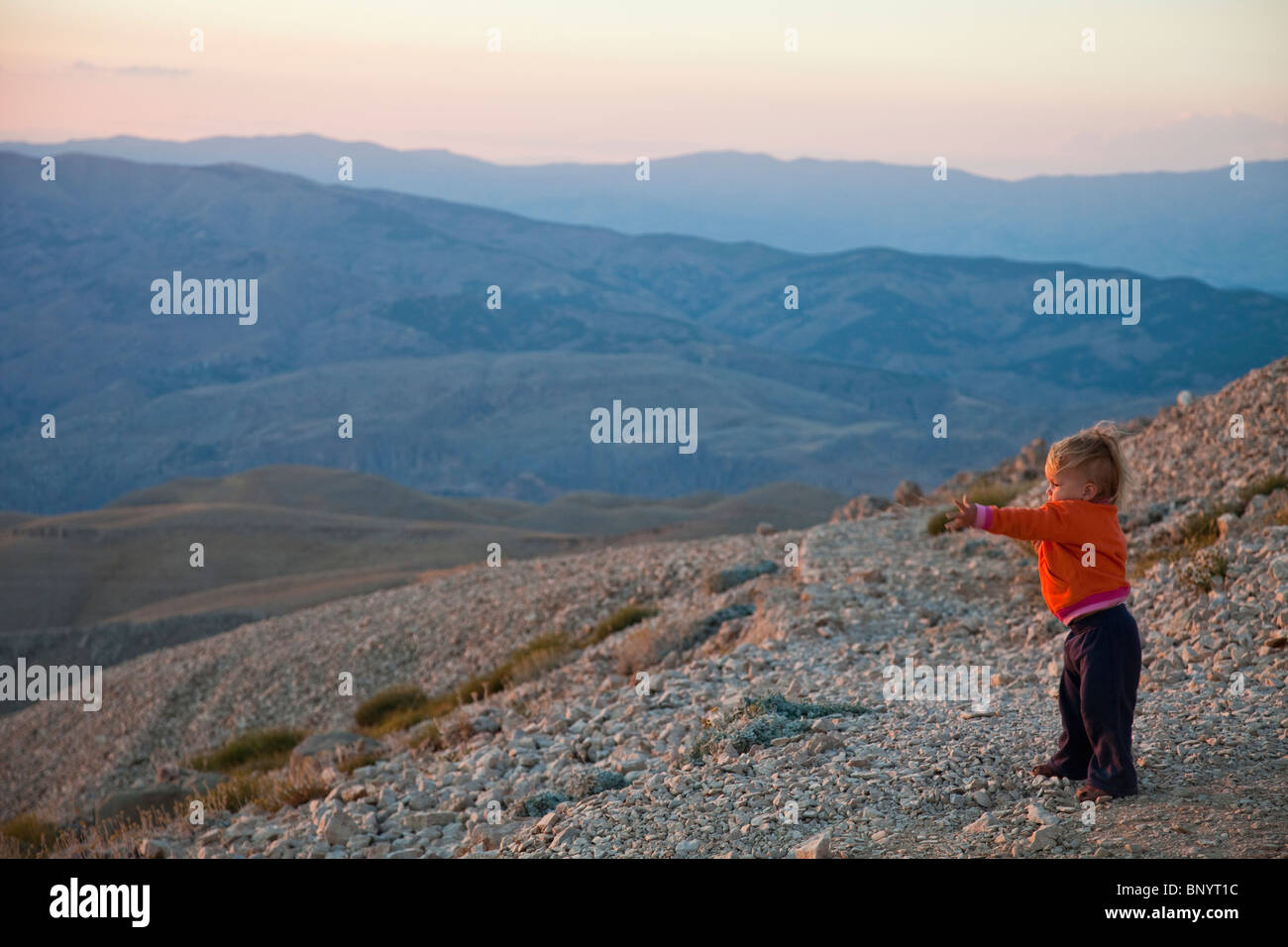 Small tourist reaching out at Mount Nimrut in Turkey Stock Photo