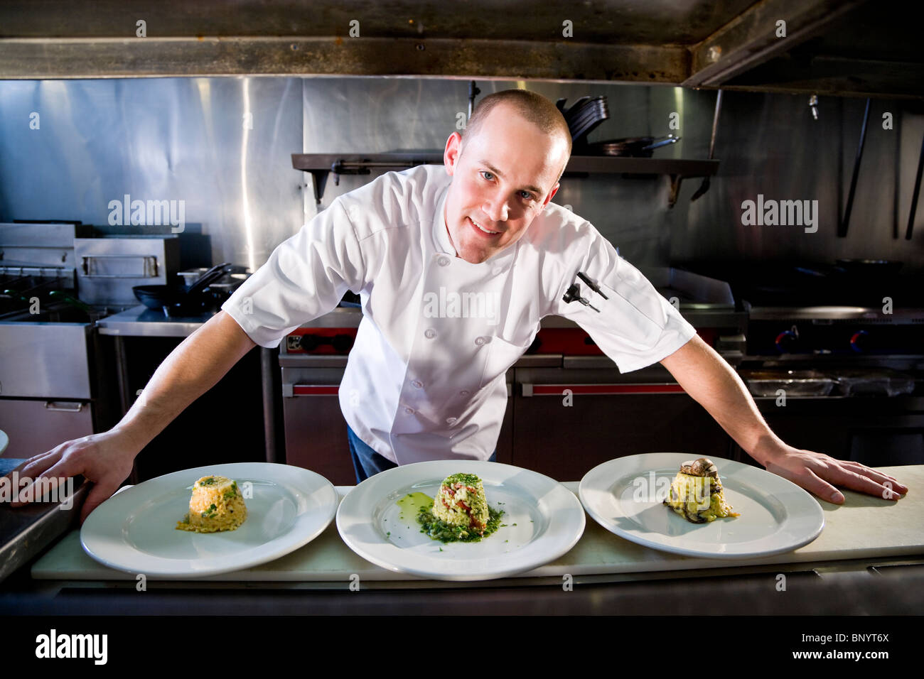 Chef in restaurant kitchen preparing gourmet dishes Stock Photo ...