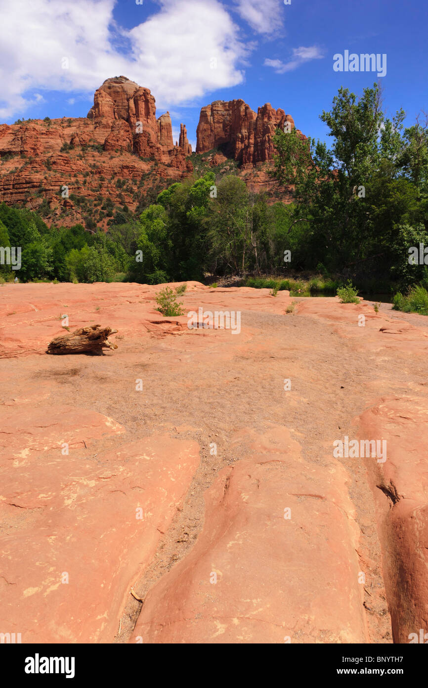 Sedona, Arizona - Cathedral Rock seen from sandstone flood plain of Oak Creek, at Red Red Crossing. Old wagon ruts in the rock. Stock Photo
