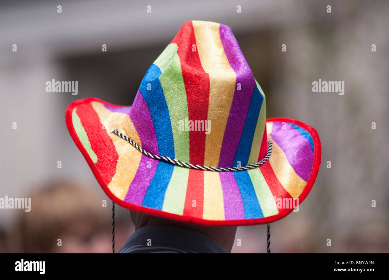 UNITED KINGDOM, ENGLAND - A man in a 'rainbow' coloured hat watches the parade pass by at Brighton Pride. Stock Photo